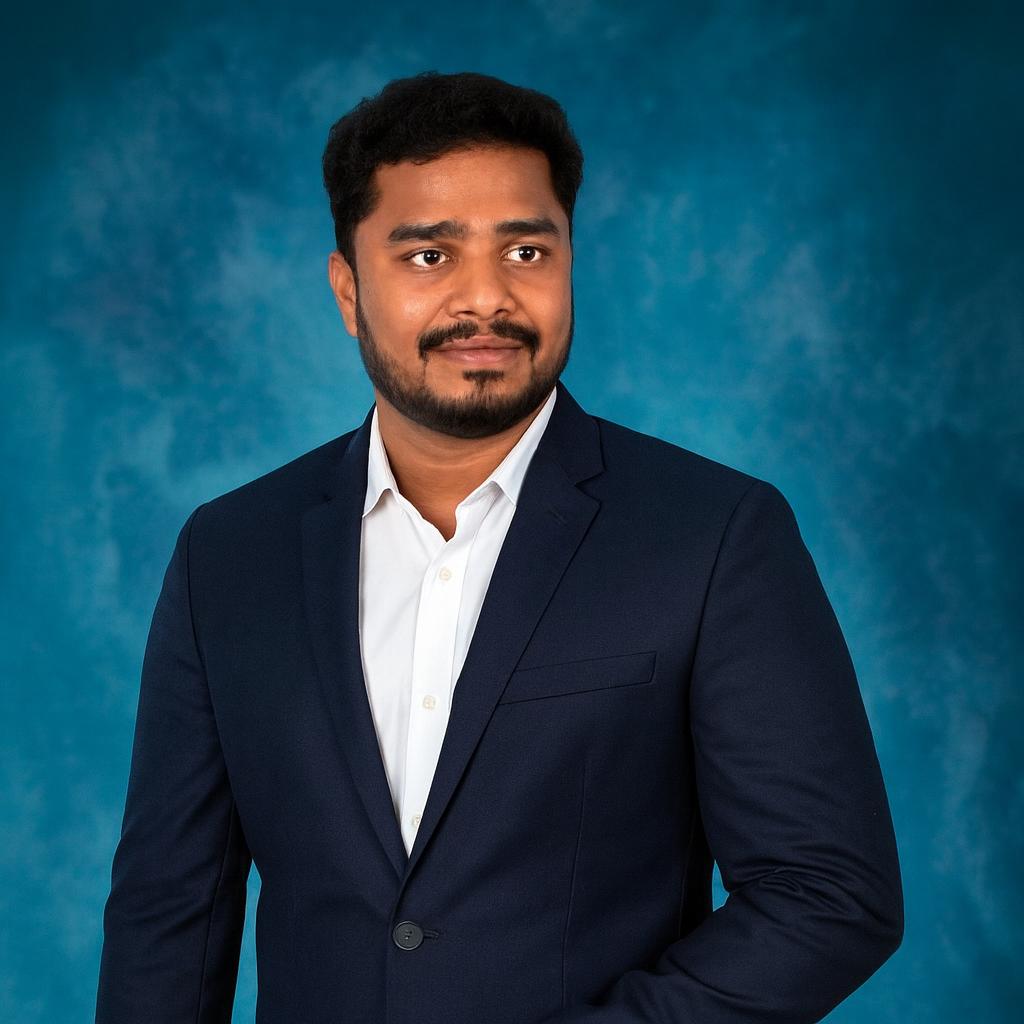 Man wearing a dark blue suit and white shirt against a blue background